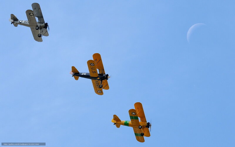 Three vintage biplanes in flight