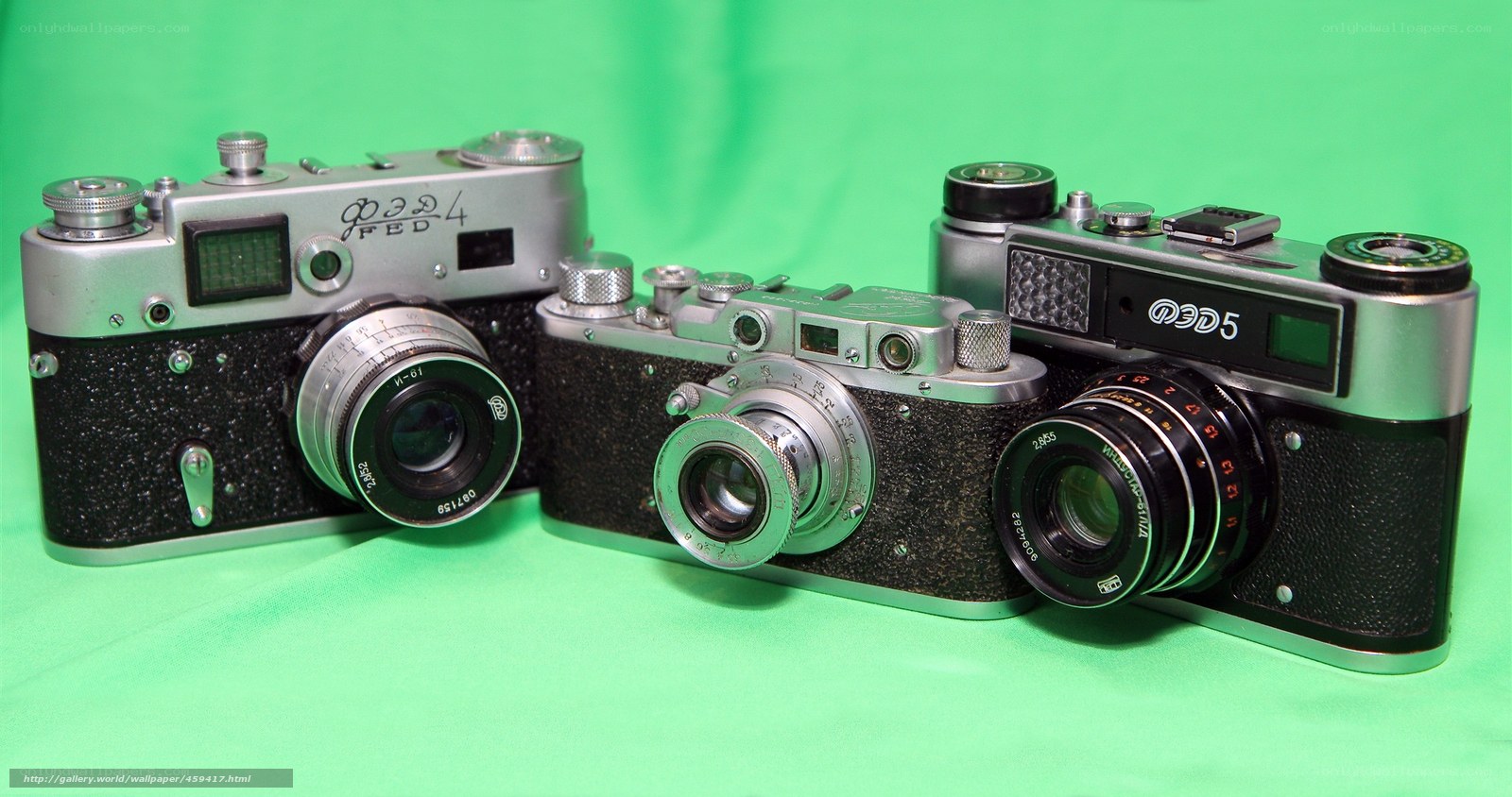 Three vintage cameras on green