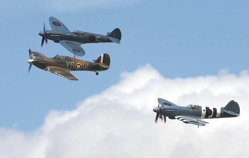 Three vintage fighter planes in flight