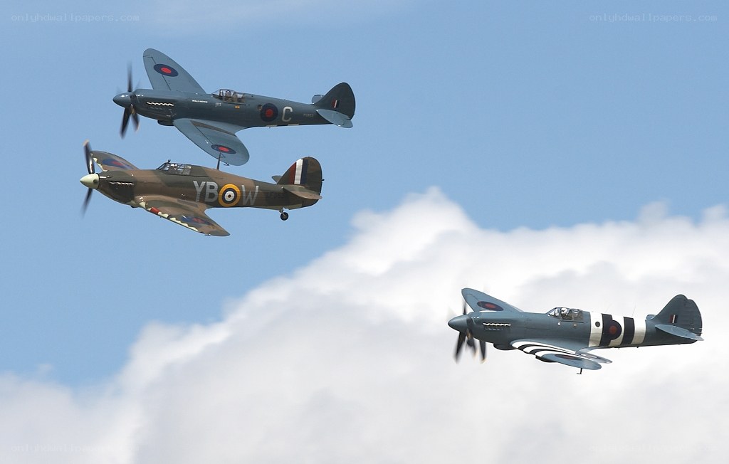 Three vintage fighter planes in flight