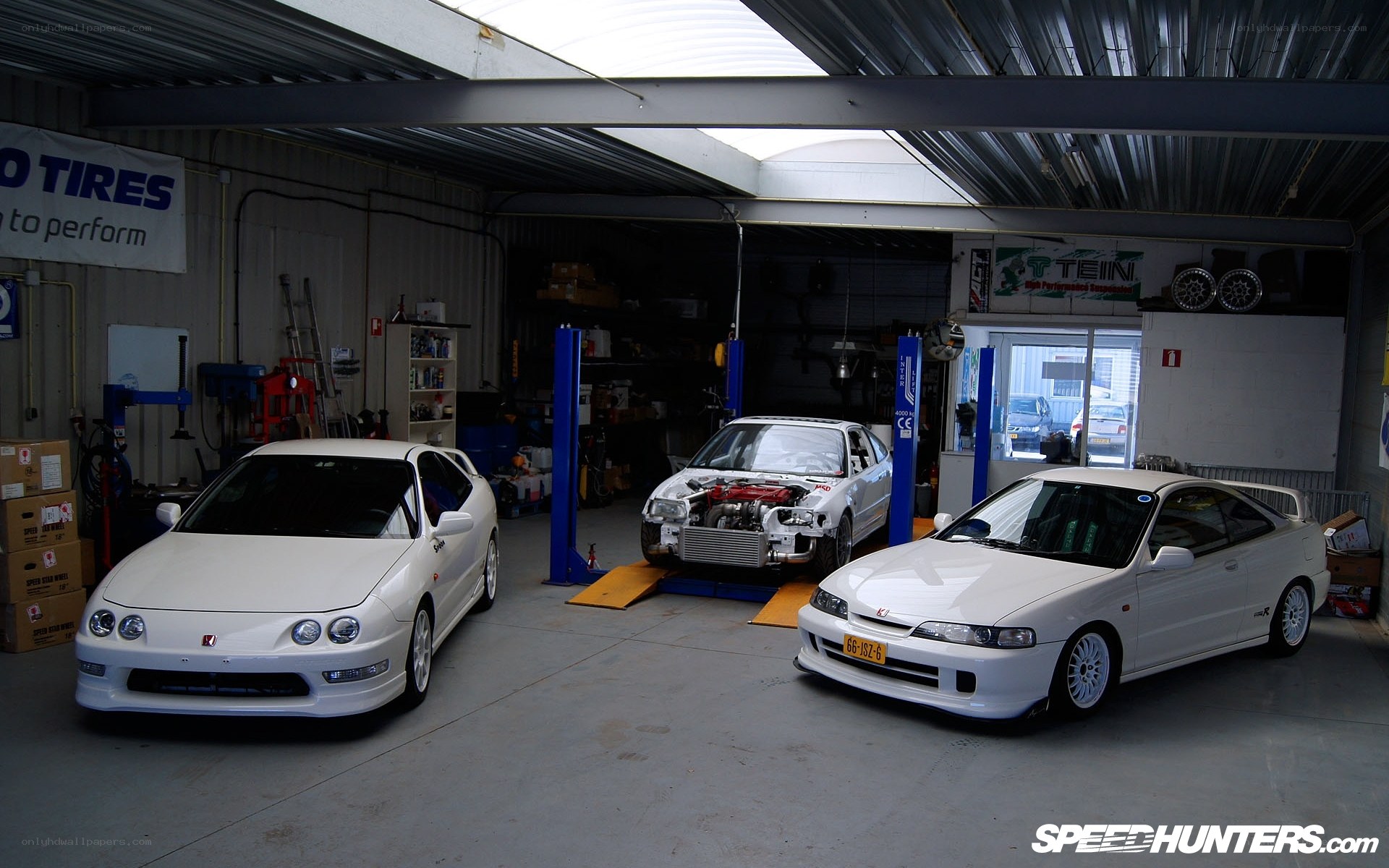 Three white Acura Integras in garage