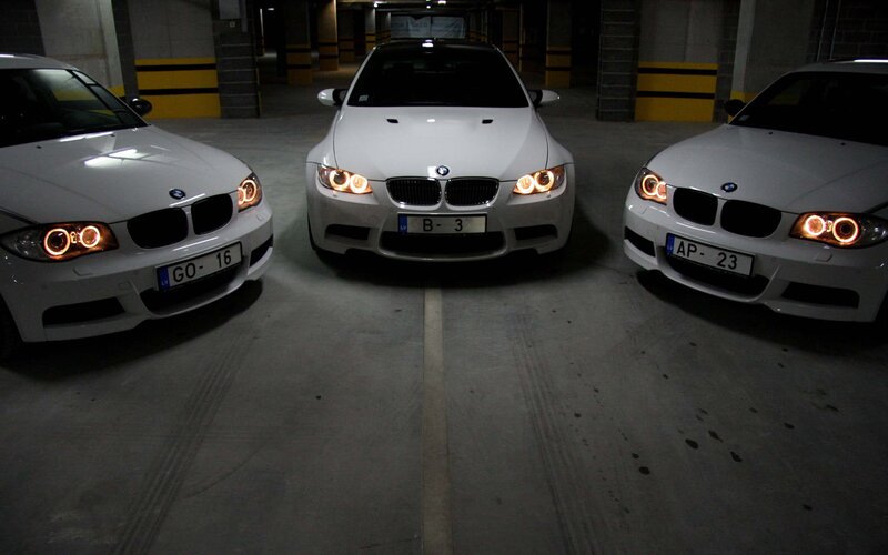 Three white BMW cars in garage