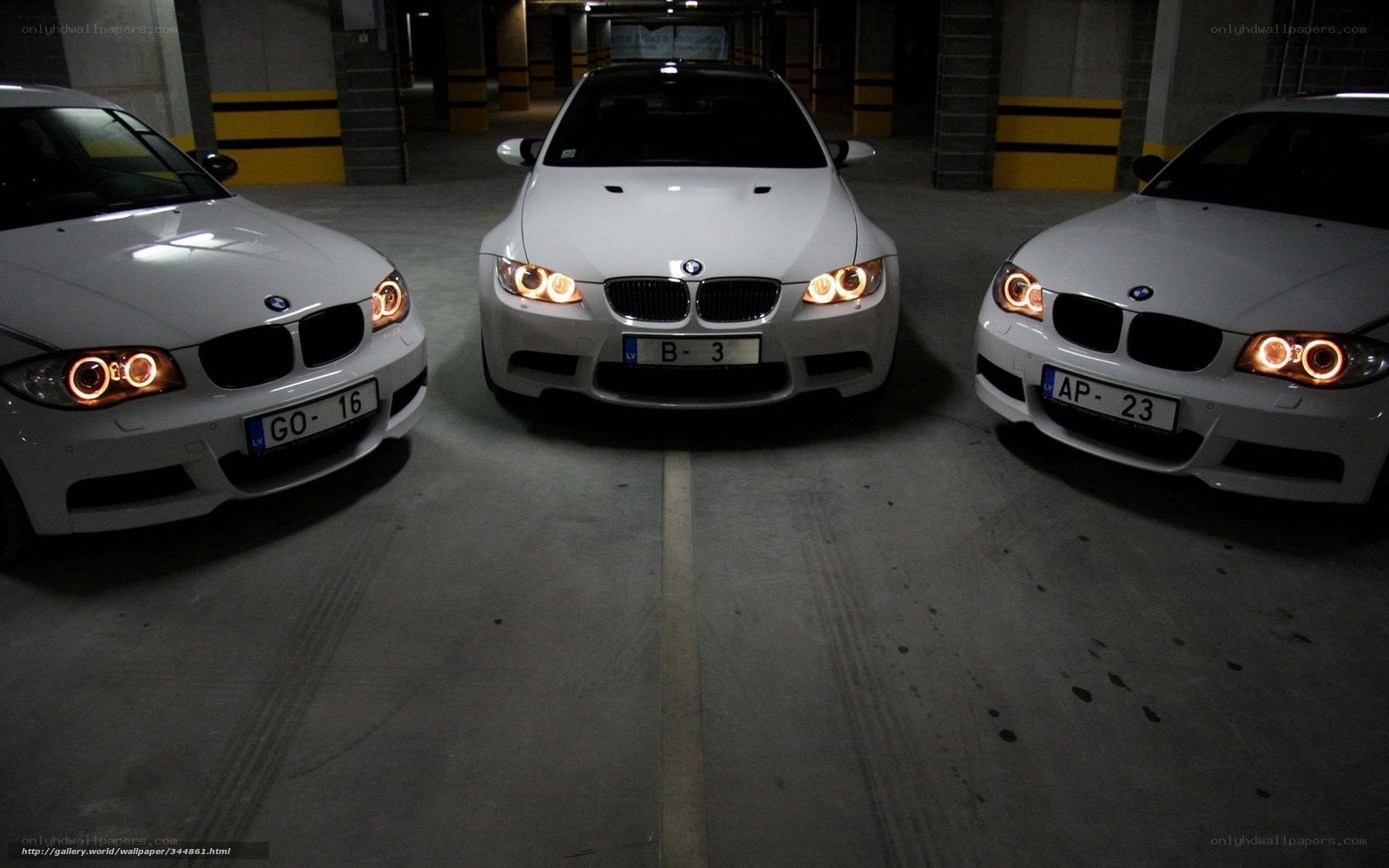 Three white BMWs in garage