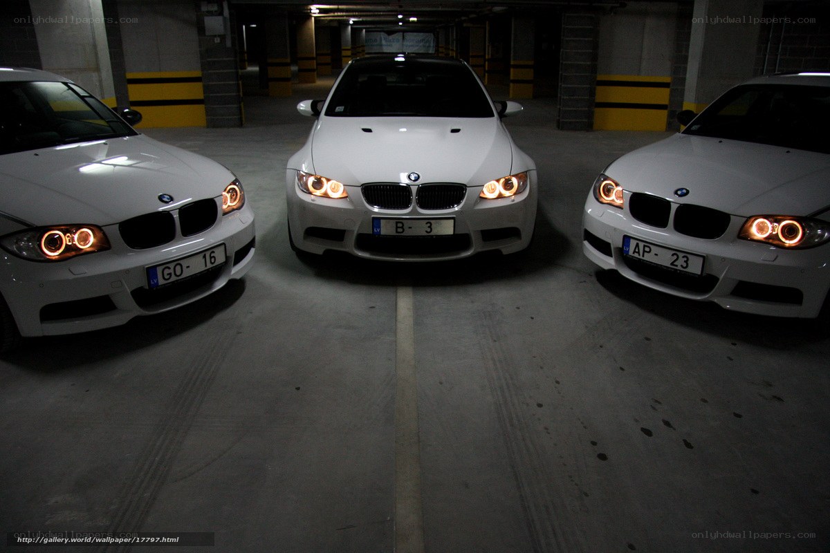 Three white BMWs in garage