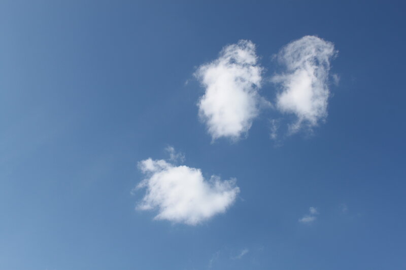Three white clouds in blue sky