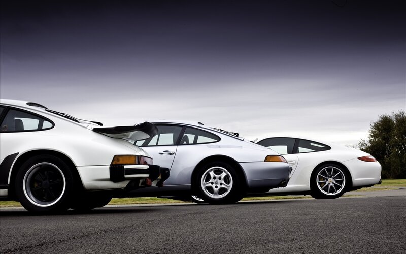 Three white Porsche cars in a row