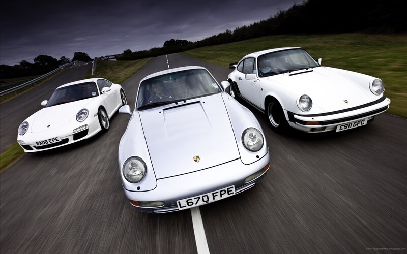 Three white Porsche cars on a track