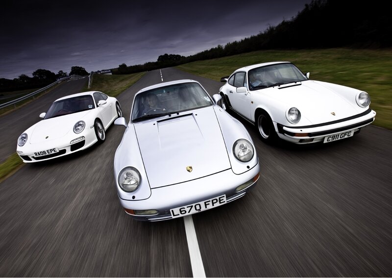 Three white Porsche cars on a track