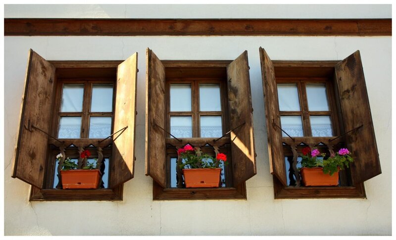 three windows with flower pots