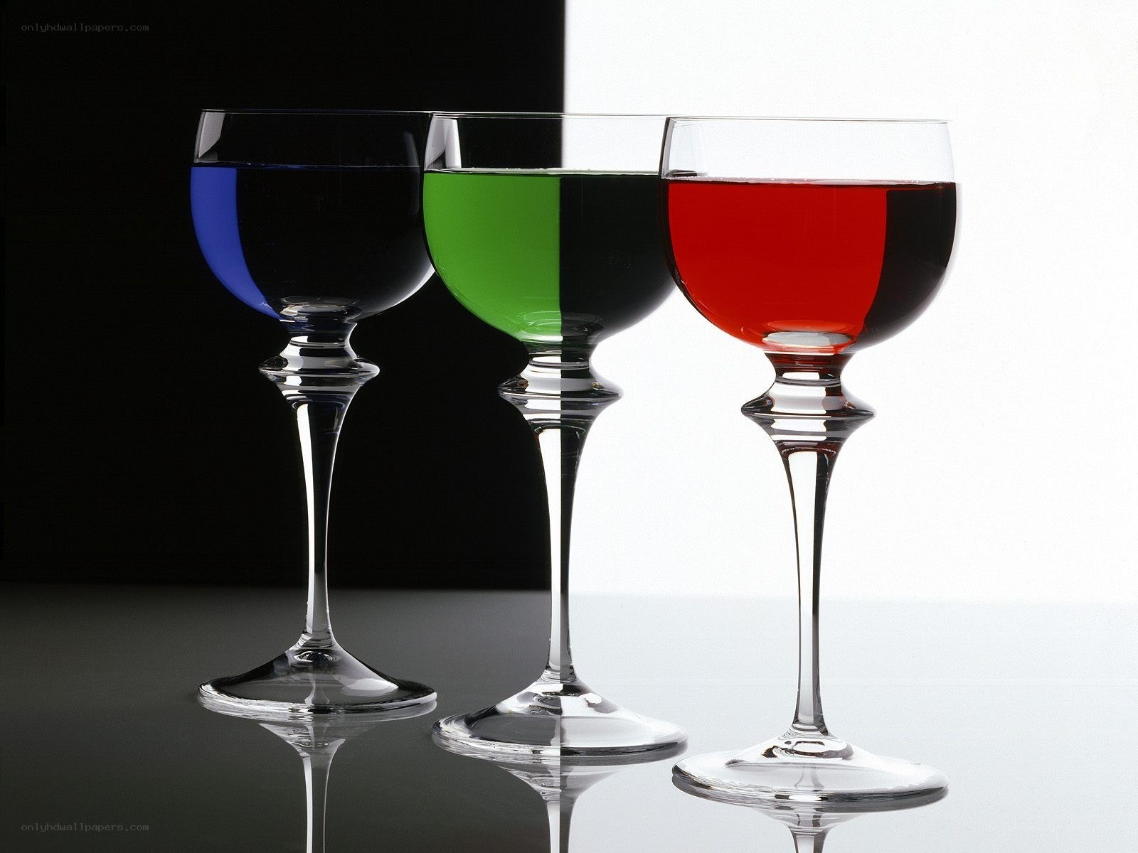 Three wine glasses with colored liquids