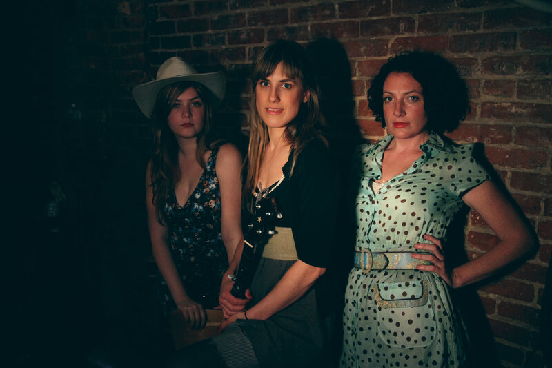 Three Women in Front of Brick Wall