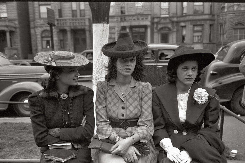Three women in hats on a city street