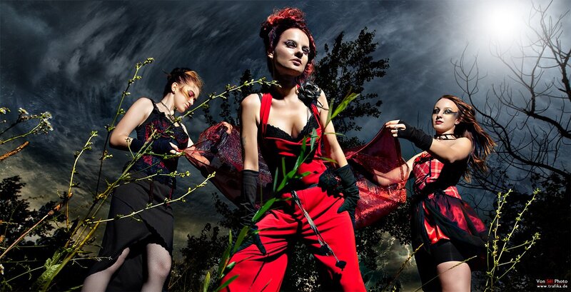 Three women in red and black costumes