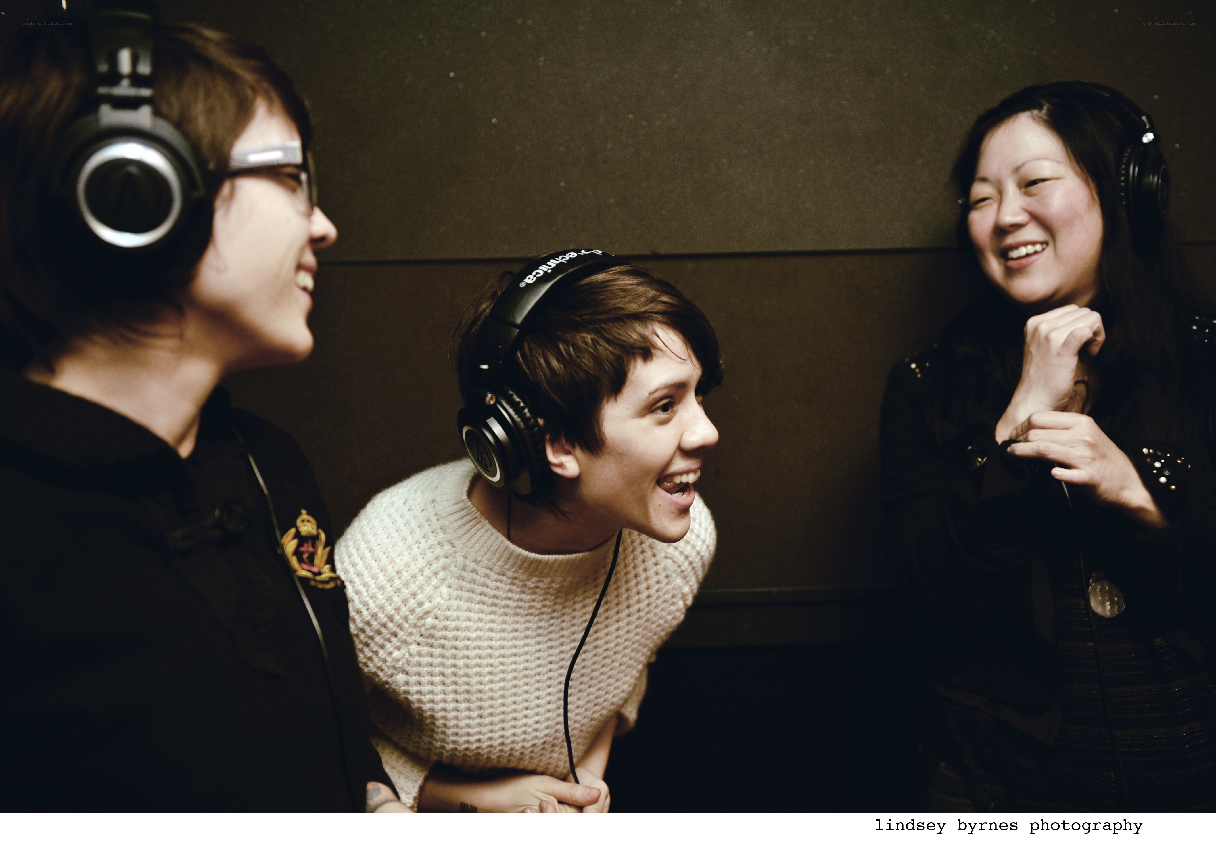 Three women laughing in a studio