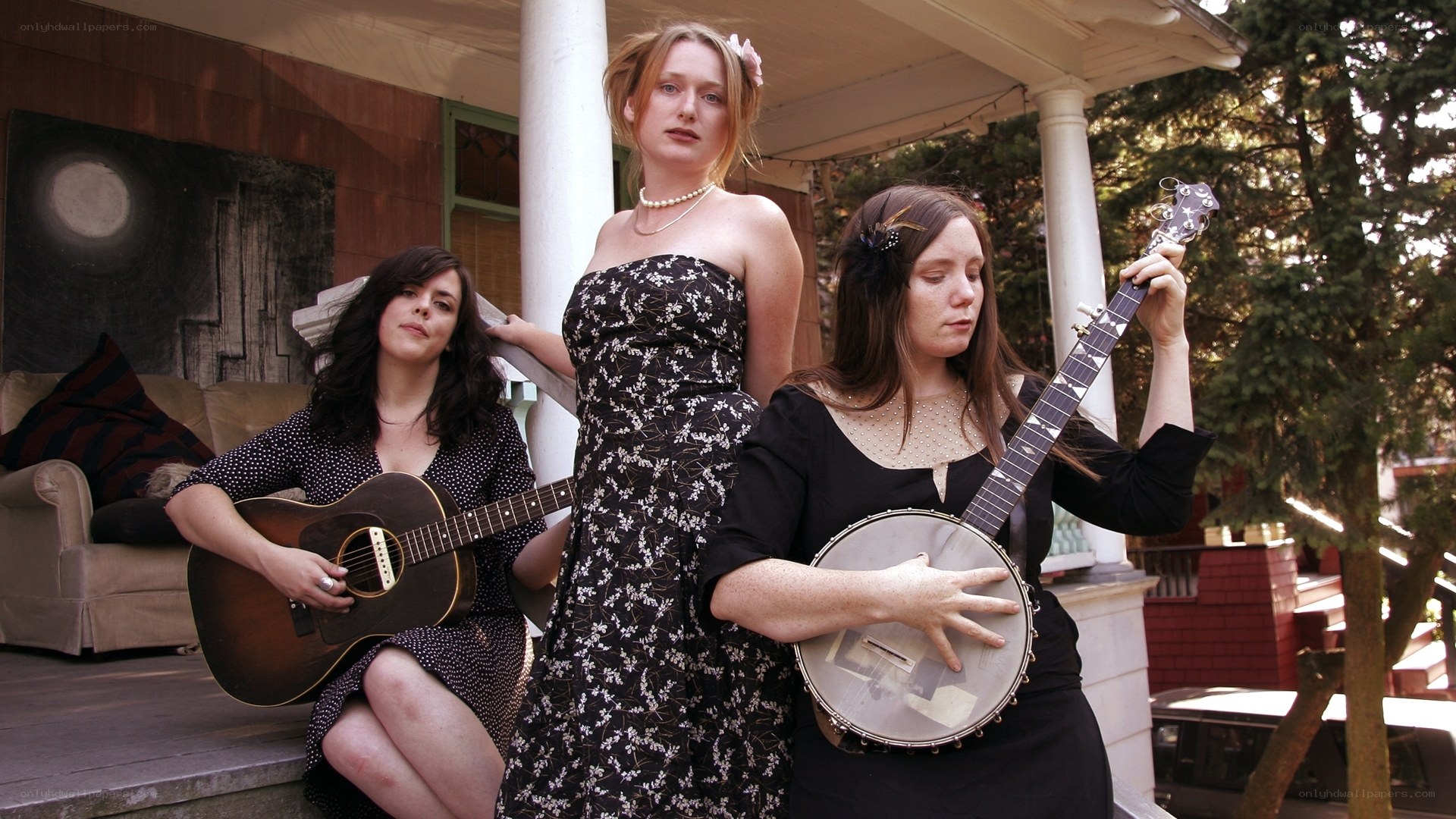 Three women musicians on a porch