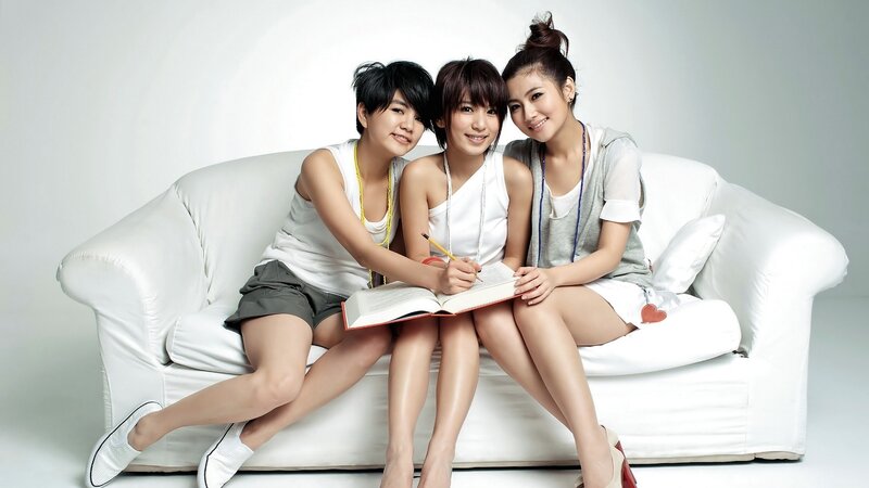 three women on a white couch