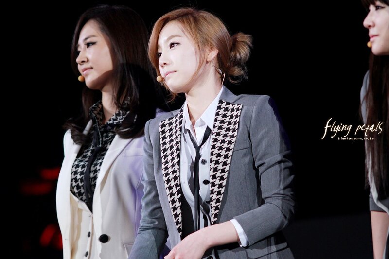 three women on stage in suits