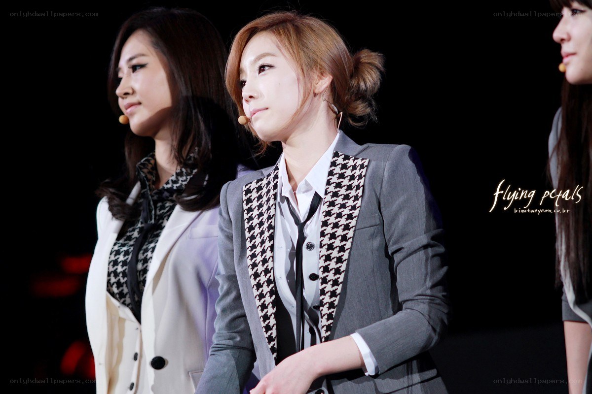 three women on stage in suits