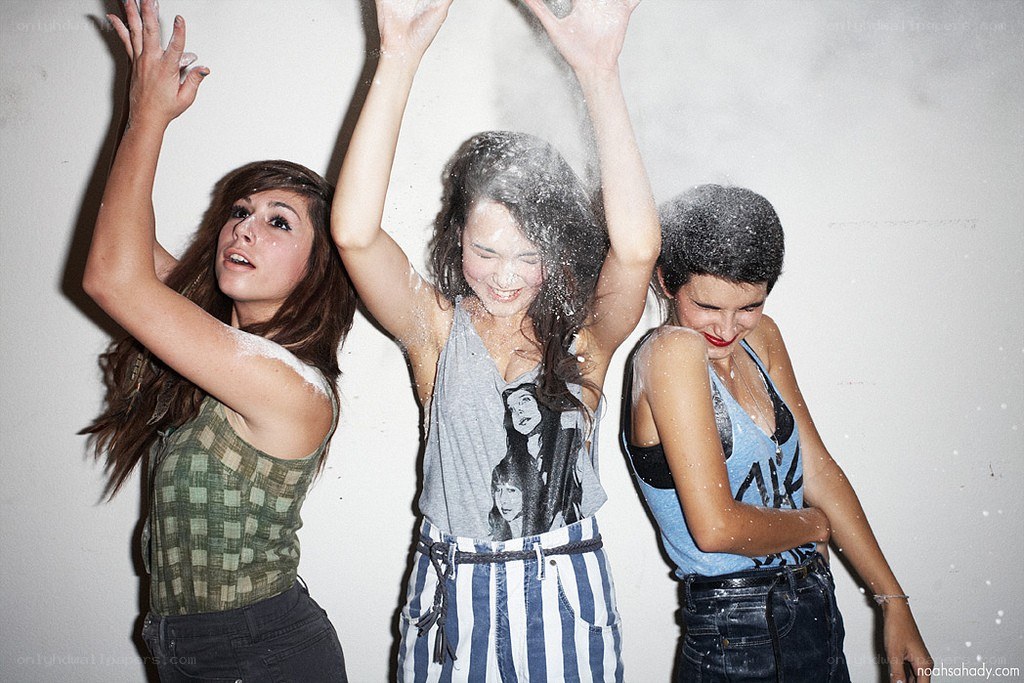 three women playing with powder