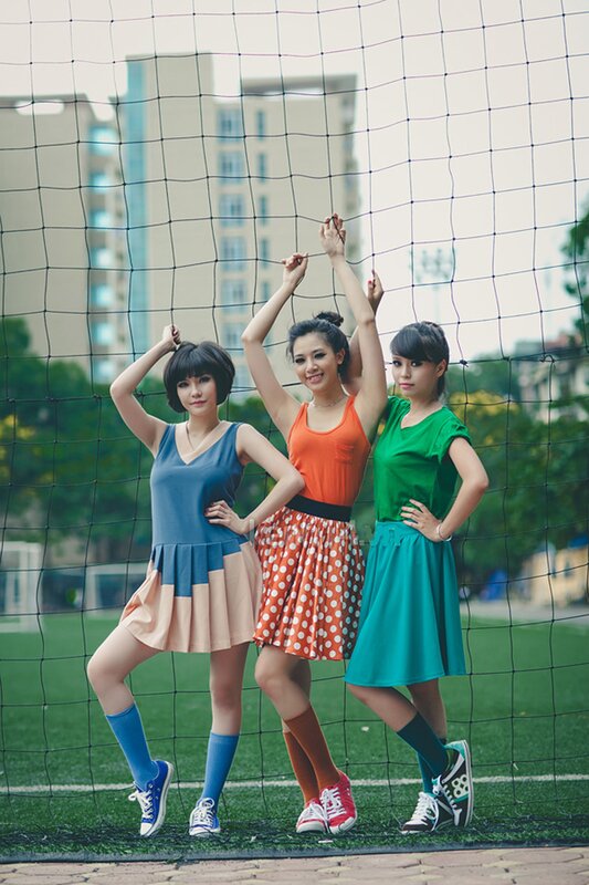 Three women posing on a sports field