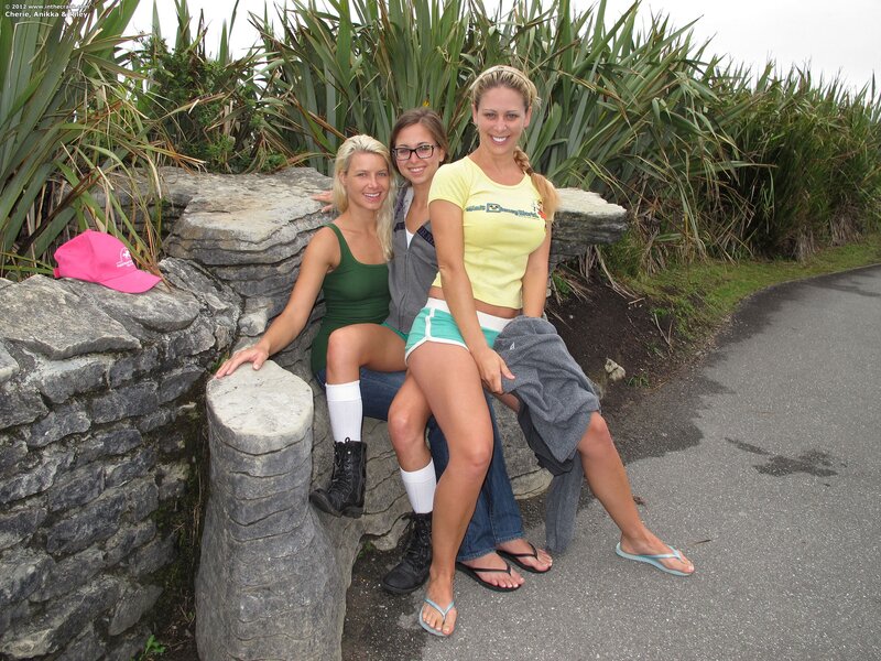 Three women posing on a stone wall