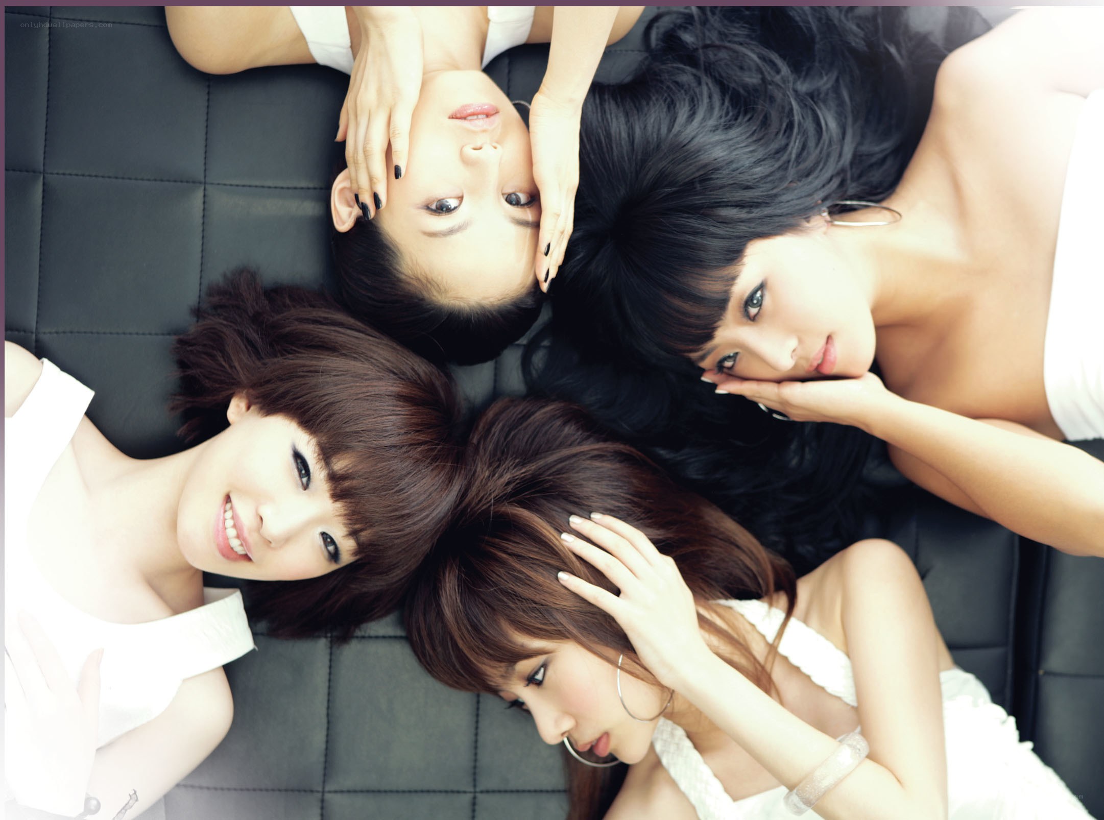 three women posing on black couch