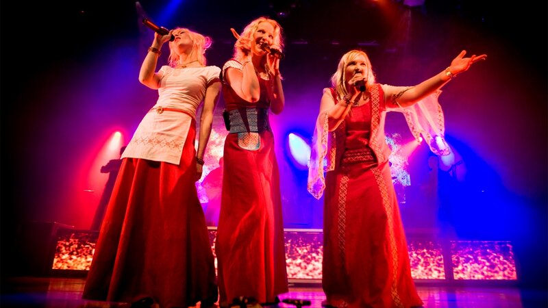 Three Women Singing on Stage — Red, Dramatic