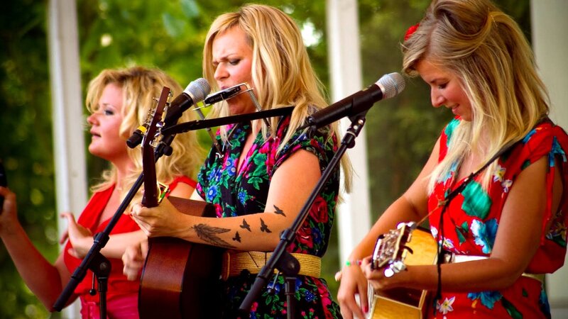 three women singing outdoors