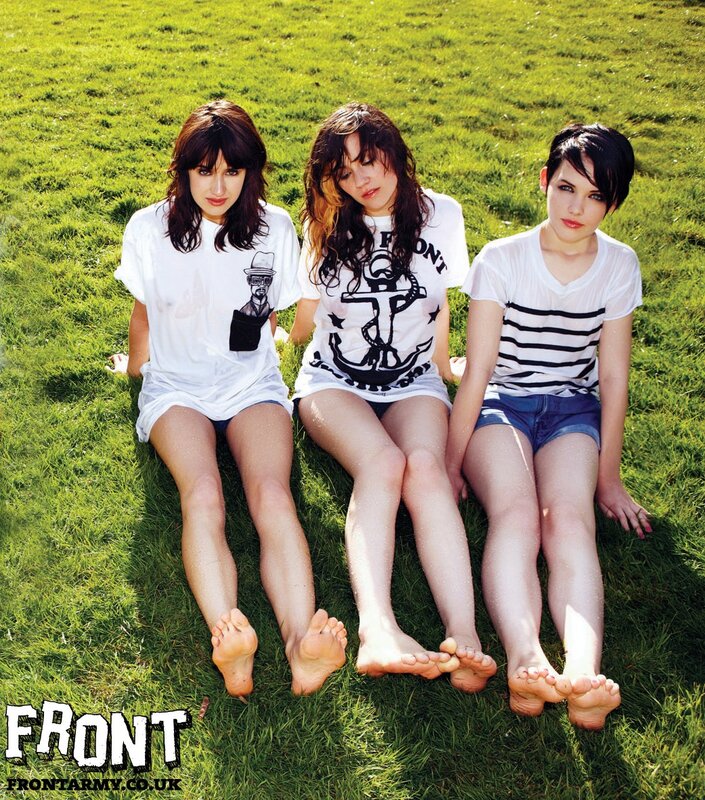 three women sitting on grass