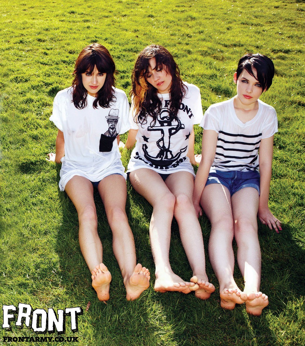 three women sitting on grass