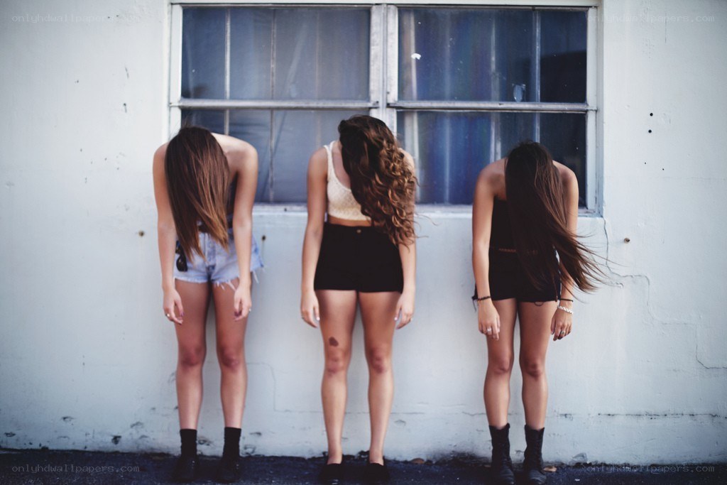 three women standing against a wall