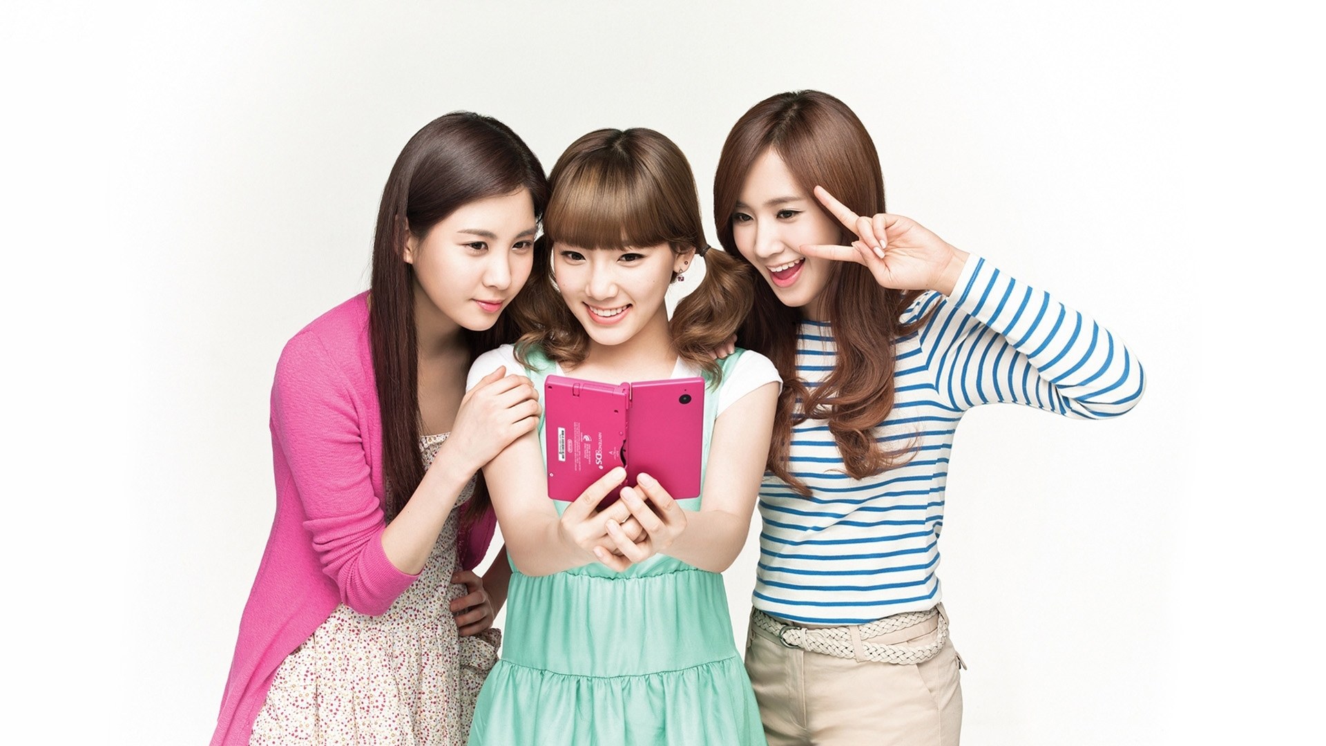 three women using a pink tablet