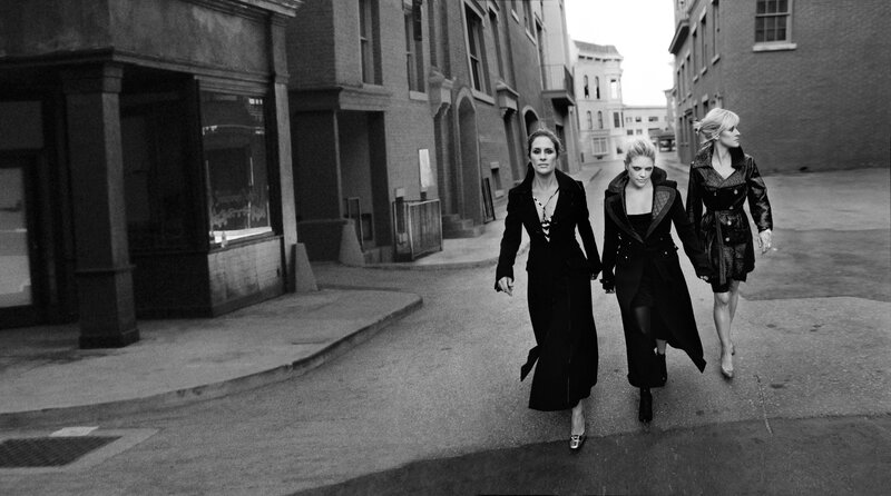 three women walking in an alley