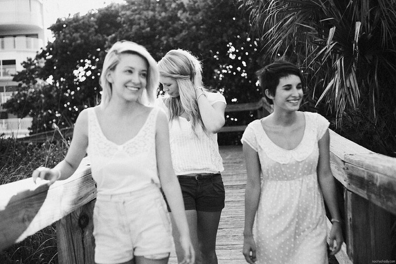 three women walking on a boardwalk