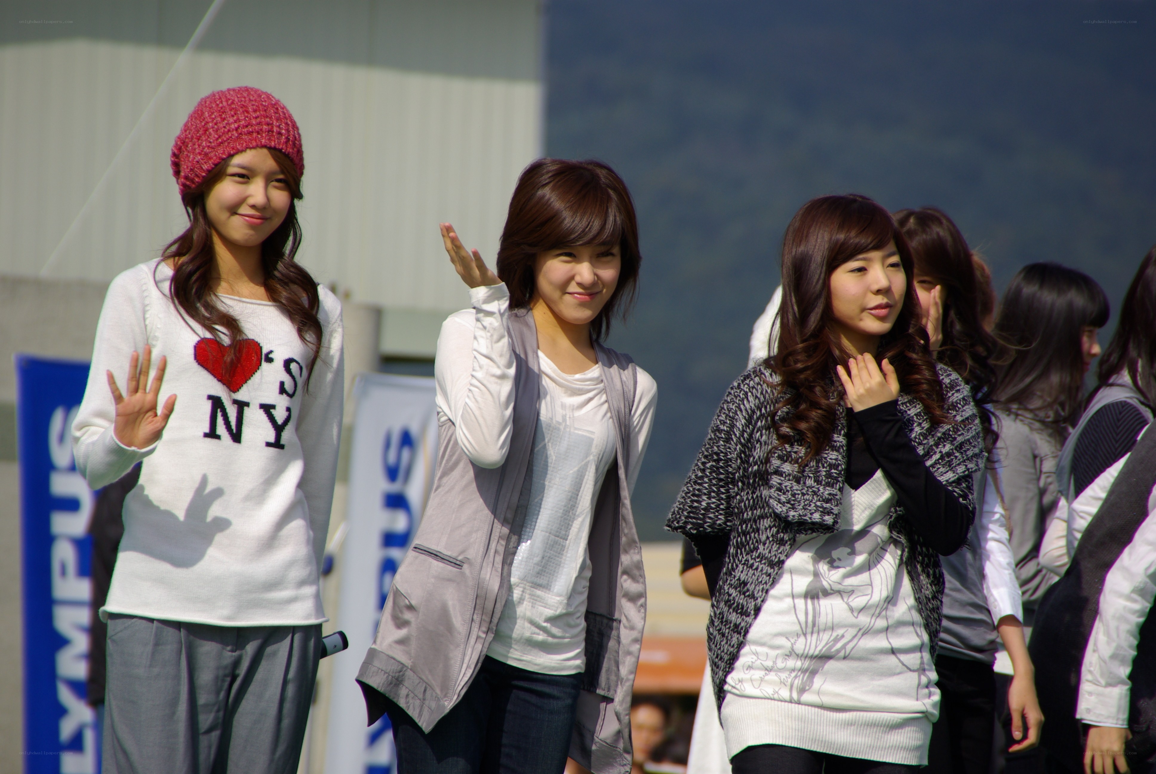 Three women waving at an event