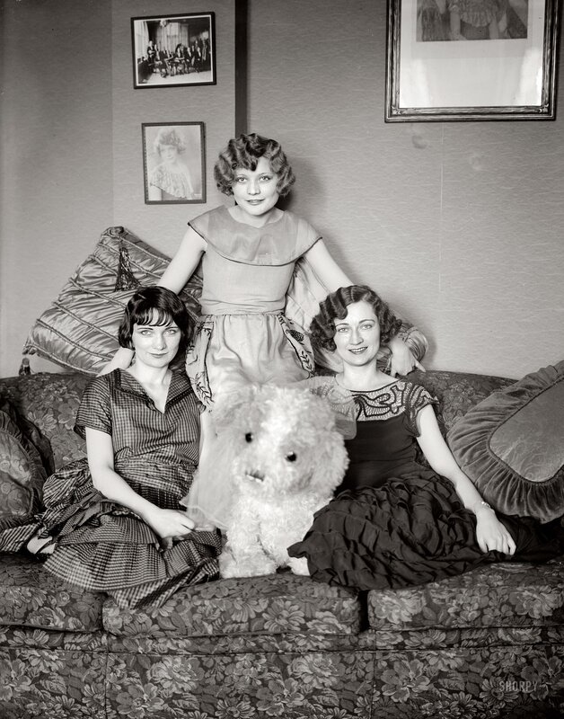 Three women with a dog on a couch