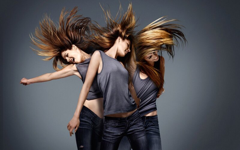 three women with hair flying