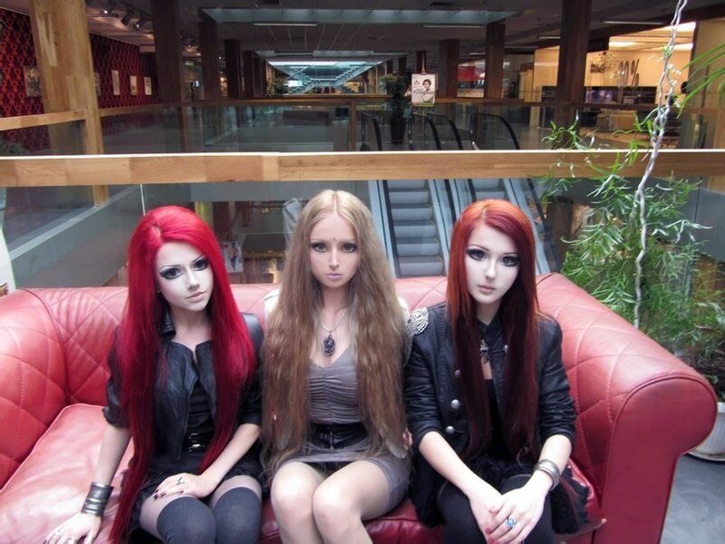 Three women with long hair on a red couch