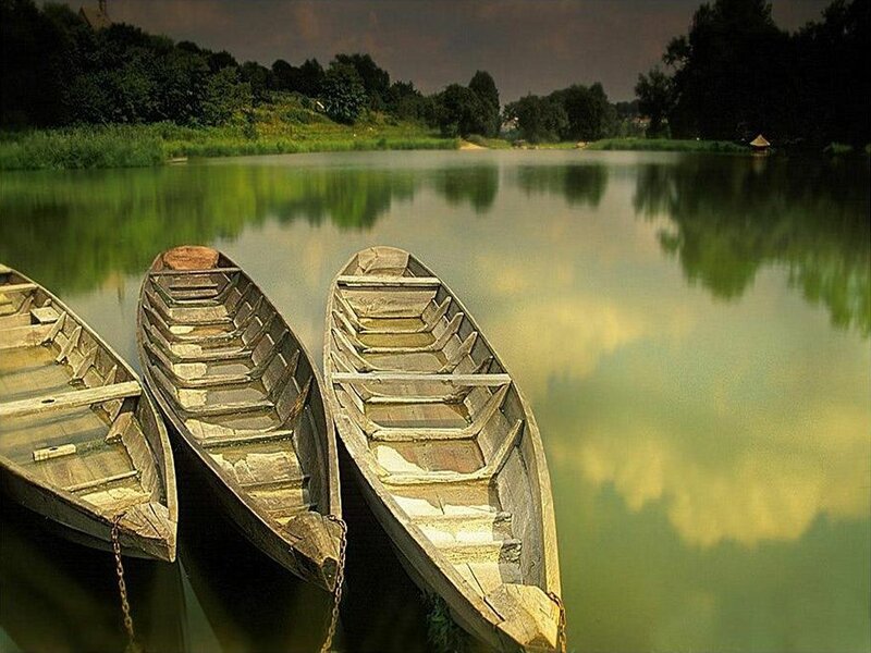 Three wooden boats on a calm lake