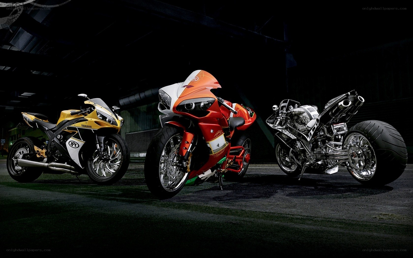 Three Yamaha motorcycles in a dark setting