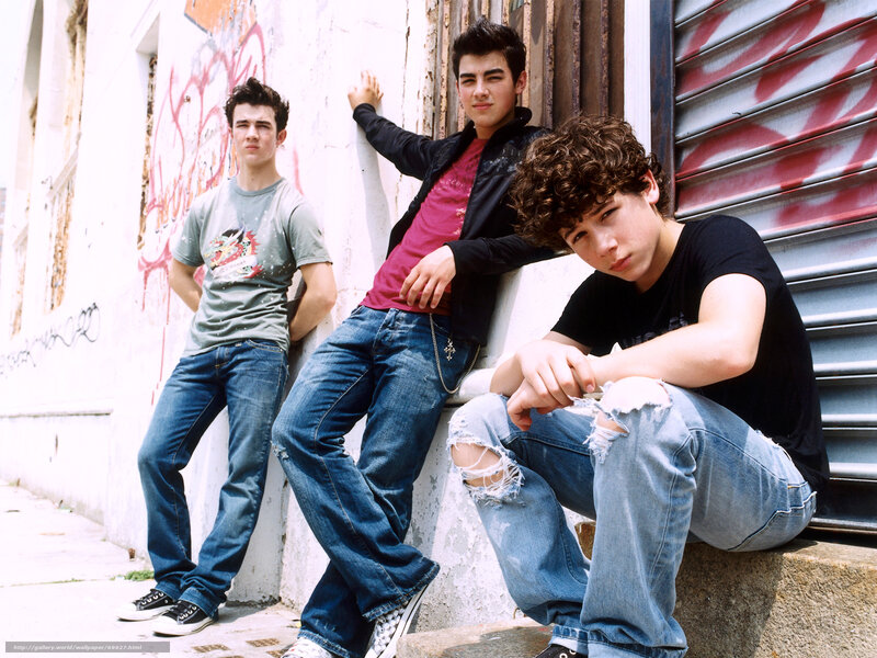 three young men posing on a street