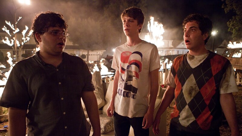 Three young men watch a fire
