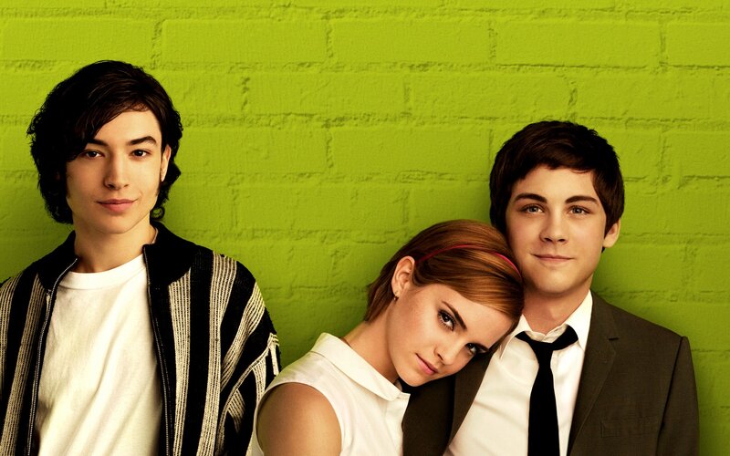 three young people in front of green wall