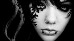 Dark eyes woman tattoos piercings