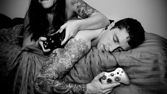 Game couple tattoos xbox controller on the bed