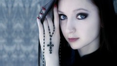 Gothic woman cross pale blue eyes black hair