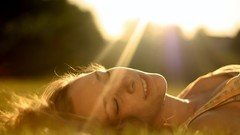 Grass woman close-up faces blondes sunlight smiling closed eyes