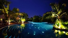 Night ocean lights palm trees swimming pools