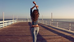 Ocean woman ass jeans outdoors long hair brunettes arms raised 