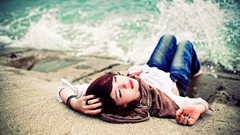 Sea coast woman rocks waves models lying down redheads